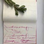 green leaves on book with praying person sketch